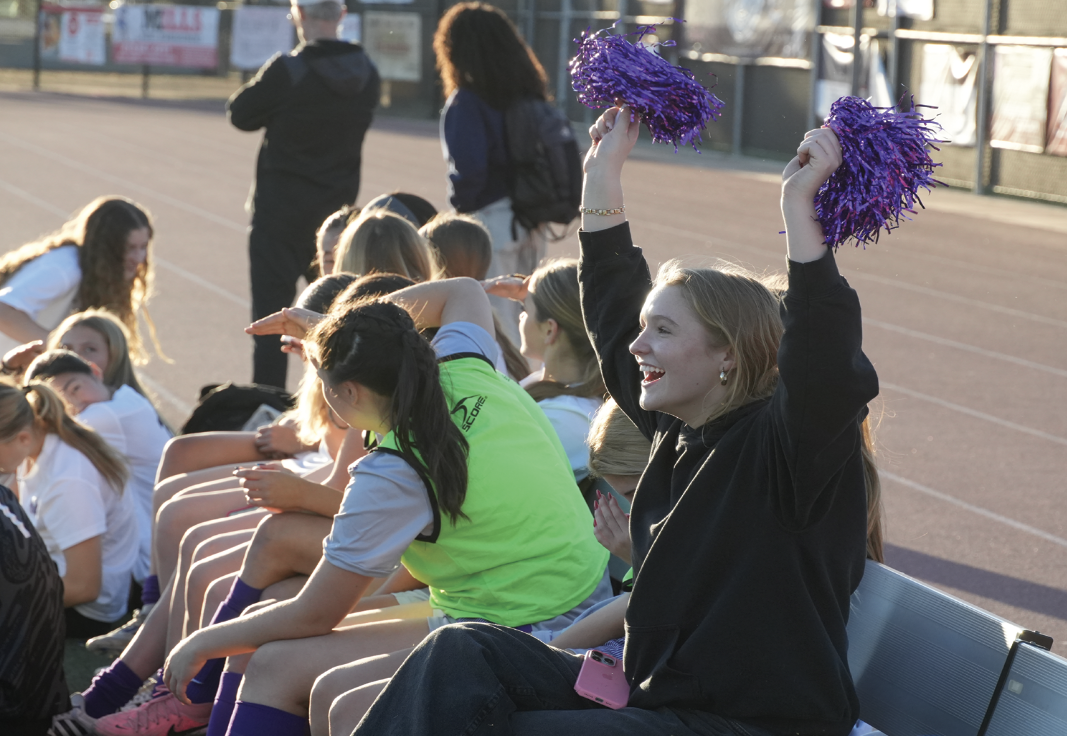 Lilly cheers for the Varsity soccer team at a game. 